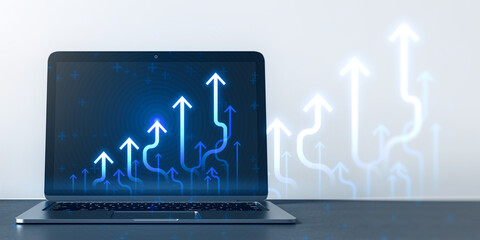 Close up of laptop computer at workplace with growing blue business chart arrows on blurry background. Success, trend and financial growth concept. 3D Rendering.