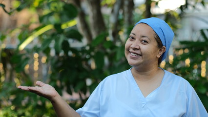 Nurse wearing operating room gown Smiling and spreading his hand so that a picture of the product was placed on his hand.