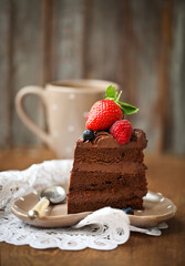 Piece of chocolate cake with icing and fresh berry