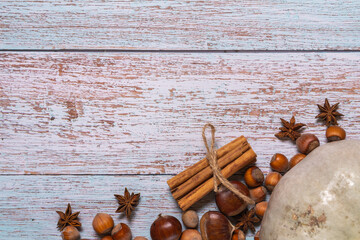  Autumn flatlay with pumpkin, chestnuts, star anise, cinnamon and cobnuts on a white wooden...