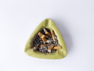 Ashtray filled with cigarette butts on a white background