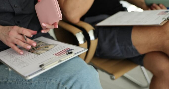 People fill out visa forms for us with passports and dollars in line at embassy. Standard process for gaining access to country and residence permit in America