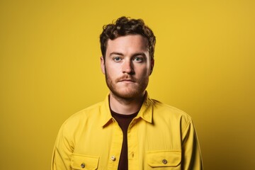 Obraz premium Portrait of a young man in a yellow shirt on a yellow background