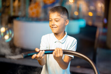 Little boy make soap bubbles, while playing together and having fun in a science museum. Concept of...