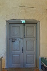 Old grey wooden door indoors in a stone building.