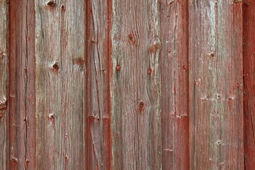 Weathered red painted plank wall.