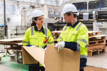 Professional worker team in safety uniform, supervisor inspector in packaging stock order at cardboard factory warehouse, piles of stacking paper manufacture, recycling industrial production