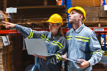 Engineer wearing safety vest controlling industrial machine working, talking with assistant worker checking first for labour with laptop computer, Officer setting a technology system in factory.