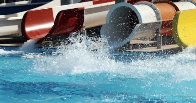 Child on water slide in water park in summer. Summer vacation and happy kids sea fun