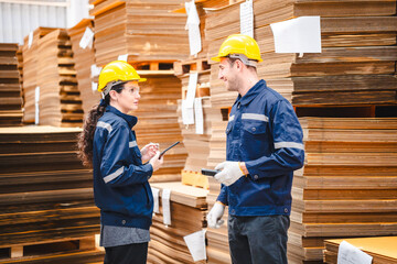 Paper and cardboard factory warehouse workers using a digital tablet while recording inventory. Logistic employees working with business management software in a large storage distribution centre