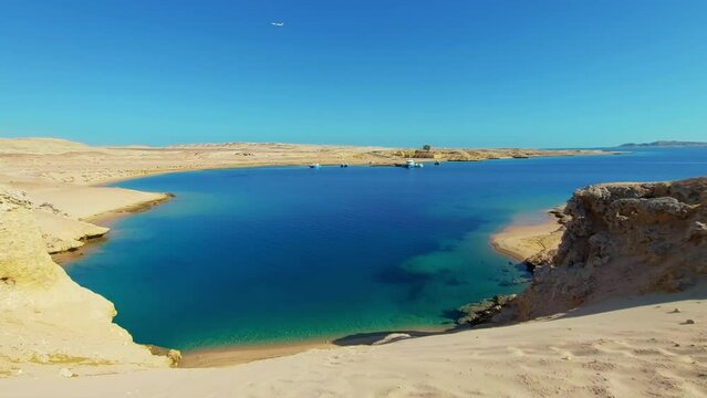 Blue lagoon in the reserve of Ras Mohammed National Park of Egypt. Tourism travel in Sharm El Sheikh, sightseeing attraction. Vacation rest holiday. Sea bay, sandy beach. Plane is flying in background