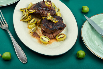 Grilled ostrich steak with kiwi berries