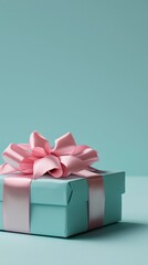 Obraz premium Stylish mint gift box with a soft pink ribbon on a pastel blue background, modern appeal