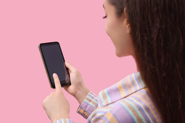 Fototapeta na wymiar Woman using smartphone on pink background, closeup. Mockup for design
