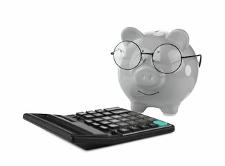 Calculator and grey piggy bank in glasses isolated on white