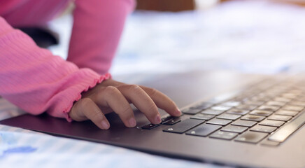 close up children girl hand type on laptop to watching media or entertainment or learning online class on website for lifestyle and technology modern concept