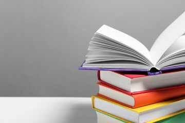 Learning foreign language. Different books on white table against gray background, closeup. Space for text