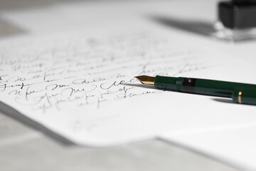 Elegant fountain pen and handwritten letter on table, closeup