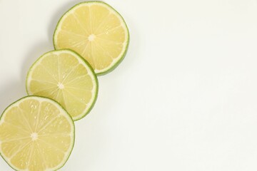 Lime pieces on white background, top view. Space for text
