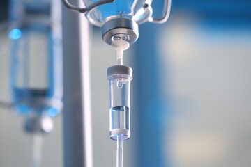 IV drip chamber against blurred light background