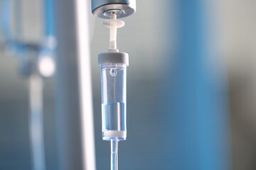 IV drip chamber against blurred light background