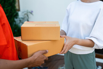 Young Asian cute girl receiving boxes from postman at the door. Delivery concept