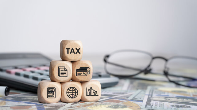 Tax concept with icons on wooden blocks Tax reduction planning, expenses, accounting, VAT and property taxes. Request a tax refund and submit taxes for online tax documents to the government.