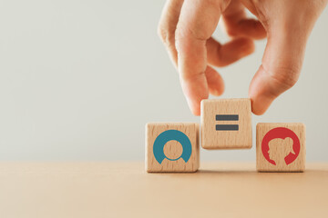 hand placing wooden cubes with equality icon between male and female sign. Equality of gender,...