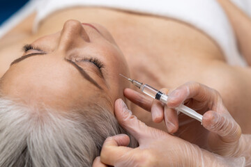 Woman having anti wrinkle filler injections to eye area