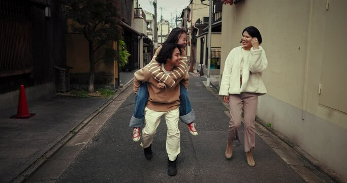 Friends, piggy back and Japanese women in city for bonding, conversation and relax together. Laugh, happy and people chat, walking and travel in Japan for holiday, vacation and adventure in street
