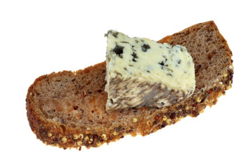 Morceau de bleu d'Auvergne sur une tranche de pain aux graines en gros plan sur fond blanc