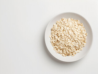 oat flakes in a white plate on a white background with copy space