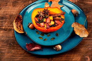 Baked half of pumpkin with fruits and spices.