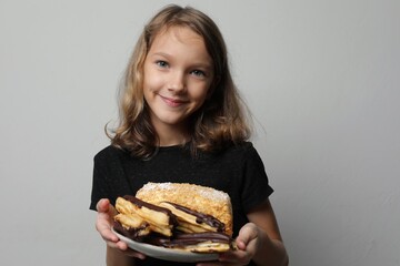 Cute girl holding plate of cakes and smiling, close-up