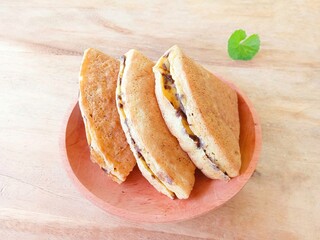 pieces of martabak filled with chocolate sprinkles on a wooden plate on a wood background. martabak, traditional Indonesian sweet snack. soft bread filled with chocolate, for tea time or celebrition