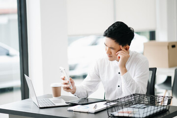 Asian businessman is stressed, bored, and overthinking from working on a tablet at office.