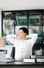 Overworked young Asian businessman office worker suffering from neck pain after had a long day at her office