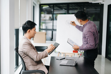 Kind leader executive manager share and discuss business solutions plan ideas on tablet with Asian male marketing manager in modern office..