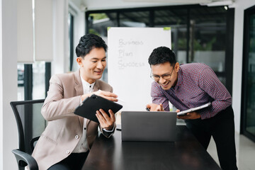 Kind leader executive manager share and discuss business solutions plan ideas on tablet with Asian male marketing manager in modern office..