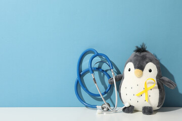 A stethoscope with a toy penguin and a yellow ribbon