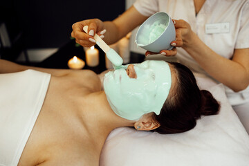 Beautician Applying Alginate Mask On Female Face With Smooth Soft Skin