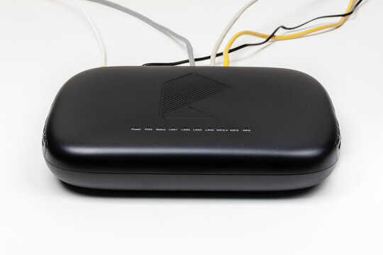Krasnodar, Russia - December 28, 2023: black gpon subscriber terminal from provider Rostelecom with connection to fiber optic Internet network and various devices with lan cables on white background