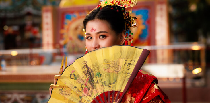 Chinese new year , Portrait of young asian woman with traditional red Chinese hong hao cheongsam in temple ,