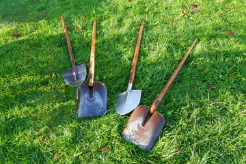 The washed shovels are lying on the grass. The concept of preparing for seasonal gardening. Careful storage, care and storage of garden equipment for the winter. © Людмила Французова