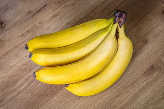 Banana on a wooden table. ripe yellow bunch of bananas on the kitchen table.