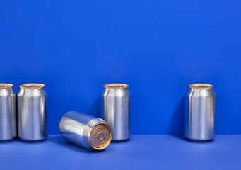 Set of aluminum cans with carbonated water on a blue background.