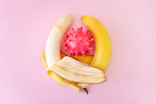 the concept of protection against sexually transmitted diseases. Condom on a banana on blue background