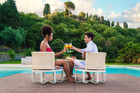 Couple Toasting Drinks by the Pool