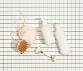 Dispensers with wash gels, roller facial massager, eco body massager. Flat lay. Facial cosmetic products.