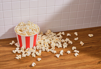 Lots of popcorn on the table. A big bucket of salted popcorn. Copy space for text.